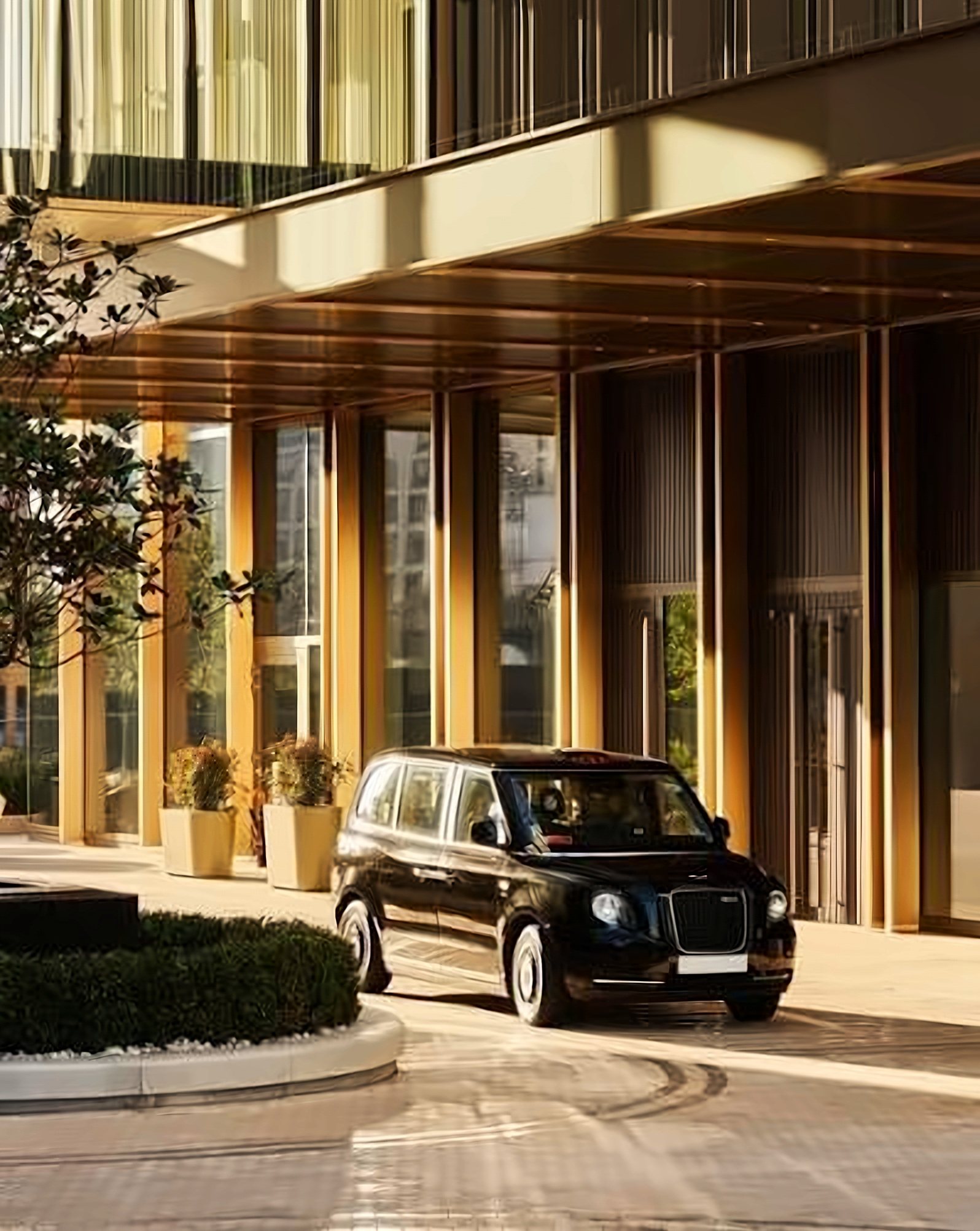 Hotel concierge in a green uniform and top hat in a wood-panelled lobby